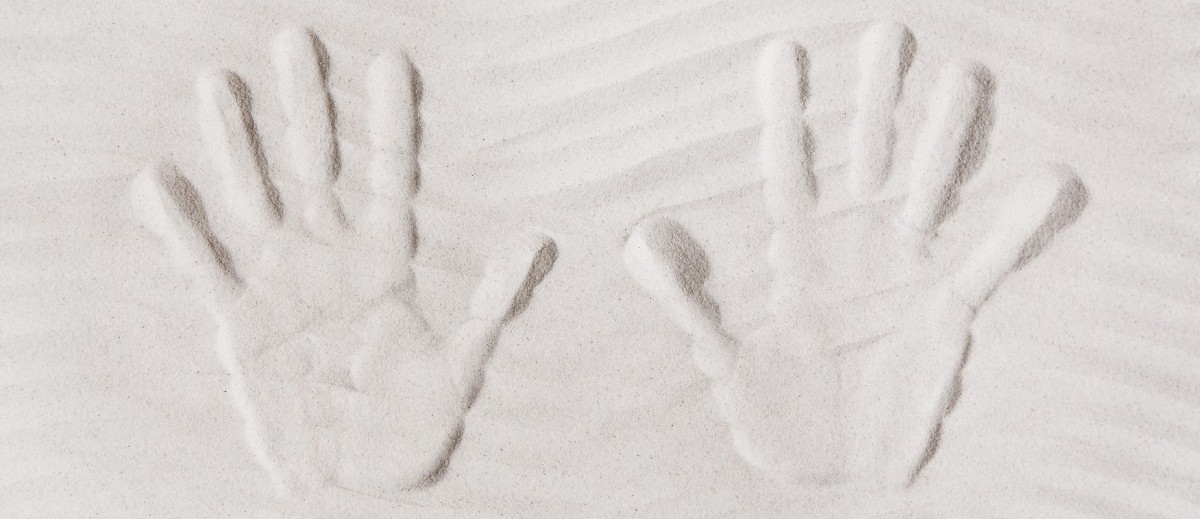 Zwei Hände im Sand
